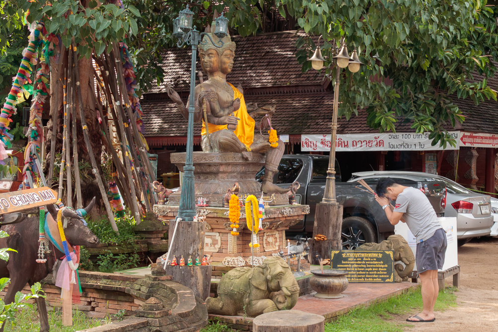 Prière devant Brahma Homme priant devant la statue Brahma au Wat Lok Moli à Chiang Mai